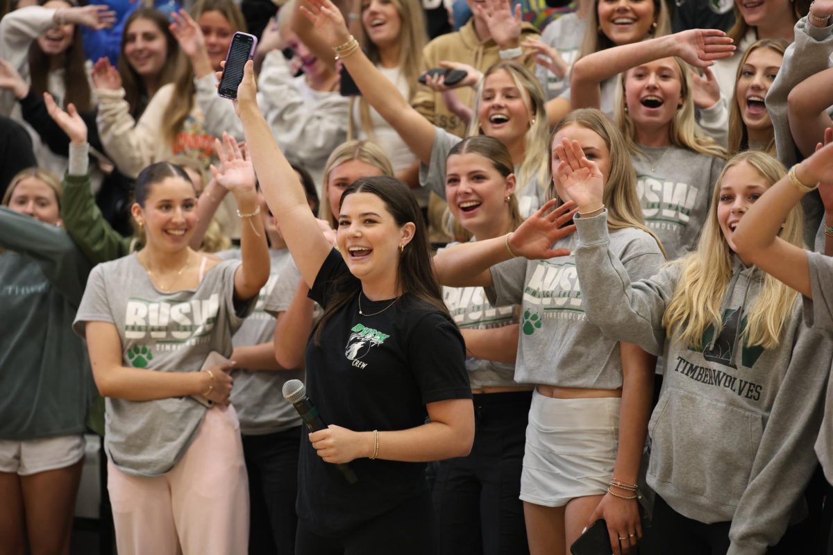 Phone in hand, sophomore Maddie Hendricks joins the sophomore class in saying goodbye to the seniors during their class chant on May 2. 