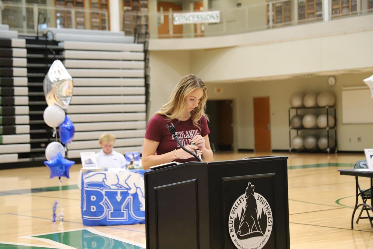 Planning to play volleyball at the University of Redlands, senior Kate Putzier signs on April 30. 