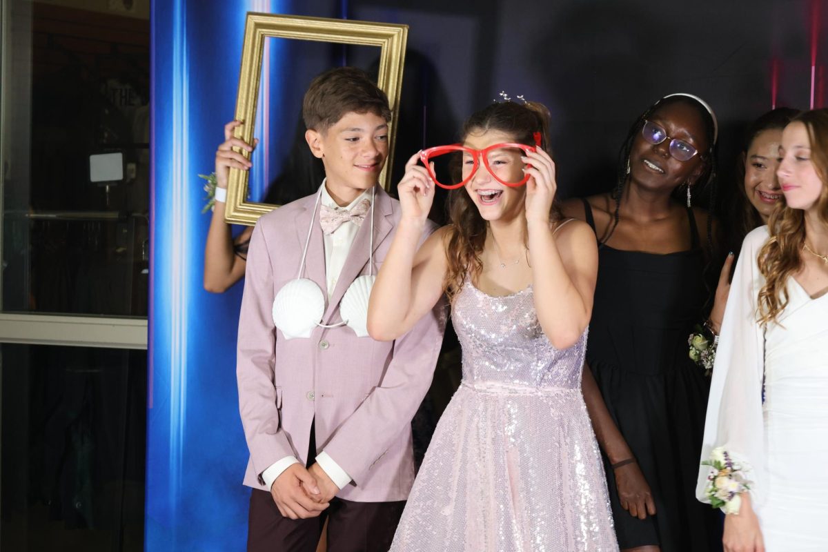 Freshmen Jovan Brown and Adalae Eichacker use props at the photo booth on Sept. 14.