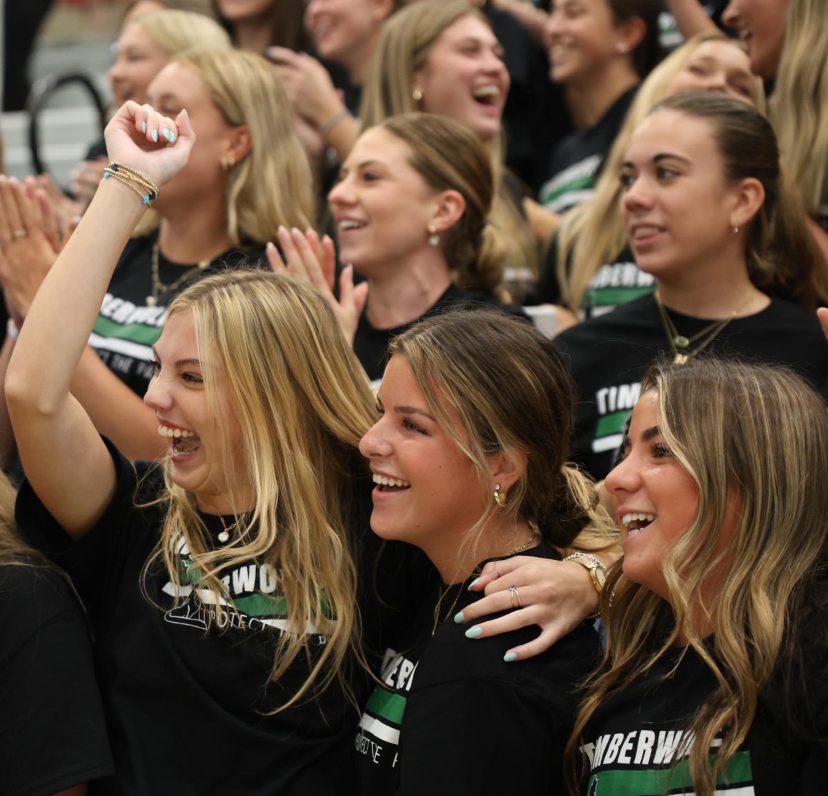 At the Back to School assembly on Aug. 16, juniors Kate Houts, Maggie Wachel and Ariel Campelo jump up and down during class chants.